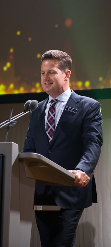 Male in suit presenting on stage
